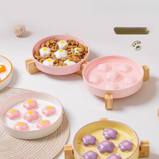 Set of pink pet bowls with different contents on a light background