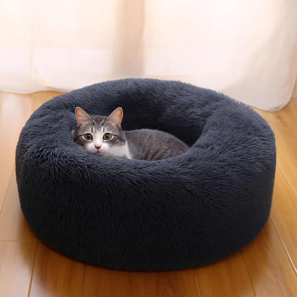Cat lying in a fluffy navy blue pet bed on a wooden floor.
